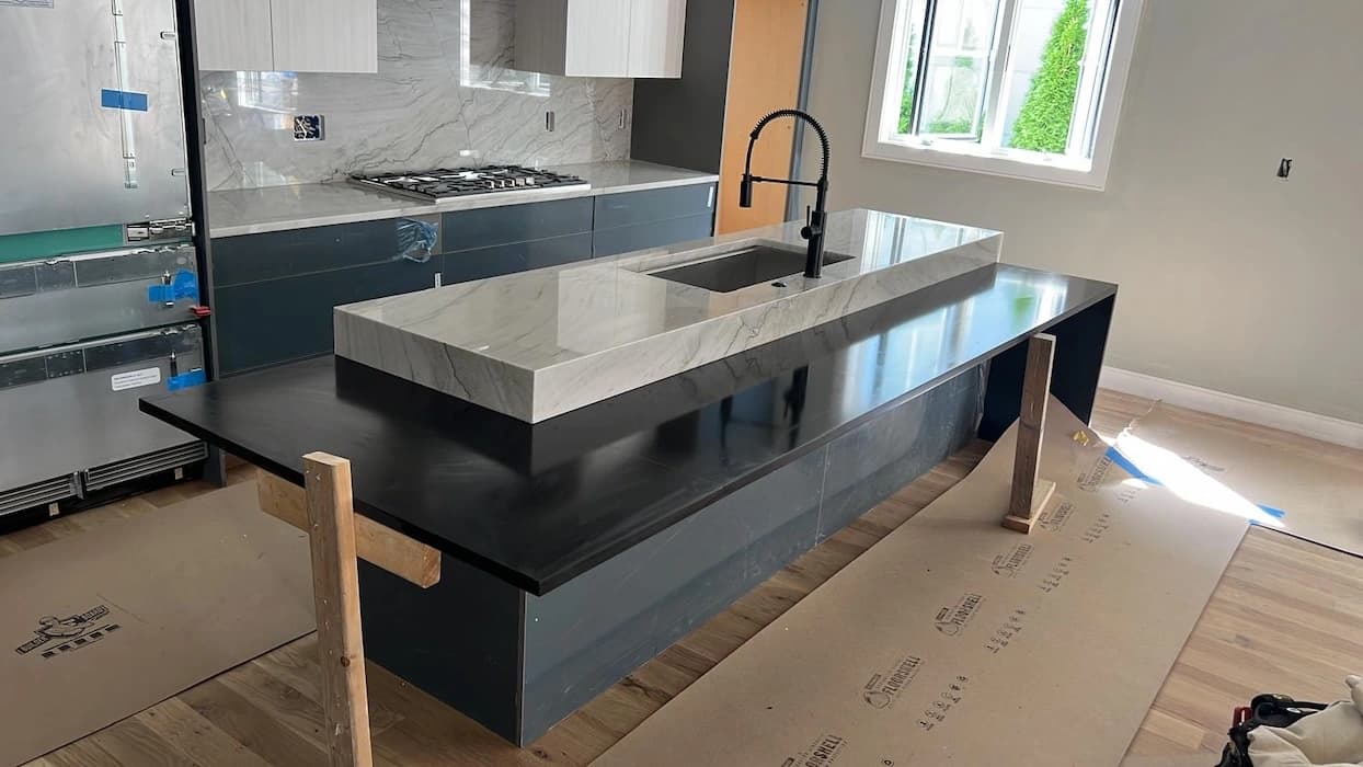 Finished marble and black granite island countertop installation by Stone Concepts